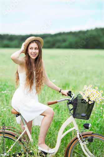 Photo: Woman on bicycle in field Woman on bicycle in field