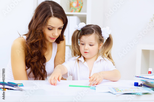 Foto: Little girl and her mother studying Little girl and her mother studying