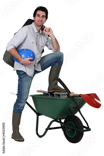 Photo: Tradesman with his foot propped up on a wheelbarrow Tradesman with his foot propped up on a wheelbarrow