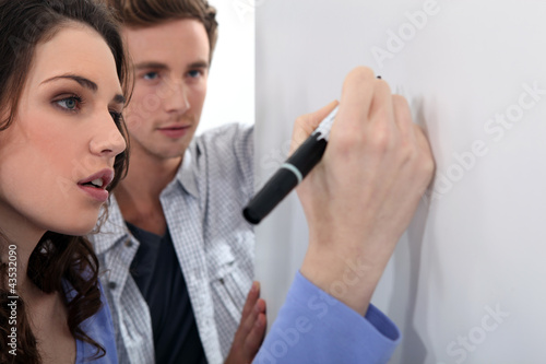 Photo: Couple working at a whiteboard Couple working at a whiteboard