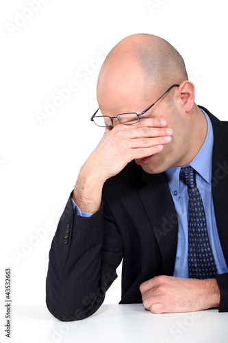 Photo: tired businessman rubbing his eyes tired businessman rubbing his eyes