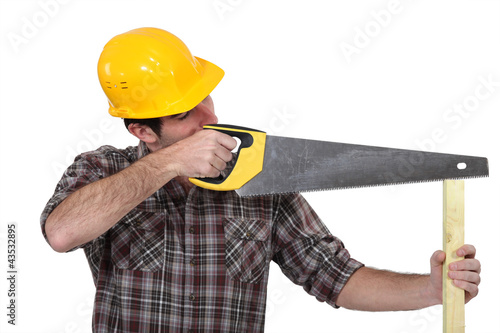 Photo: A carpenter with a handsaw. A carpenter with a handsaw.