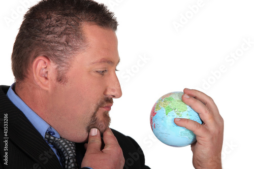Photo: Businessman looking at a globe Businessman looking at a globe