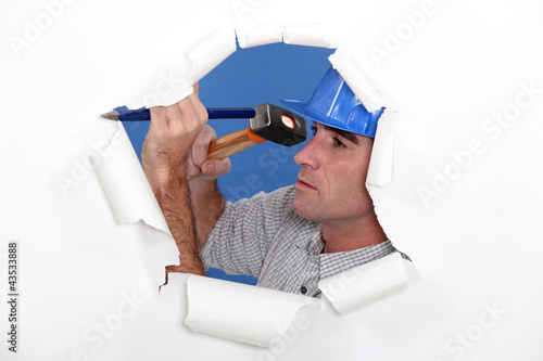 Foto: Manual worker using hammer and chisel Manual worker using hammer and chisel