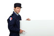 Man in a French gendarme uniform pointing at a blank board