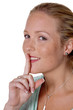 Frau mit Finger am Mund