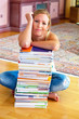 Studentin mit einem Stapel Bücher und Computer
