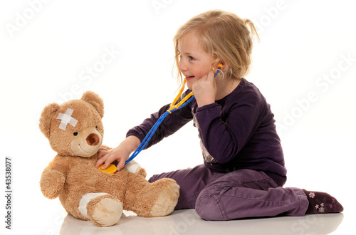 Photo: Kind mit Stethoskop als Arzt. Kinderarzt untersuch Kind mit Stethoskop als Arzt. Kinderarzt untersuch