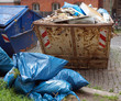 Müll-/Baucontainer mit Müllsäcken davor