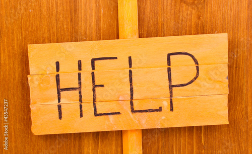 Photo: Help wooden board on wooden background Help wooden board on wooden background