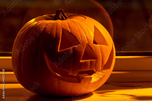 Photo: Halloween pumpkin with scary on the window at night Halloween pumpkin with scary on the window at night