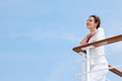 Beautiful happy woman stands on board of large ship