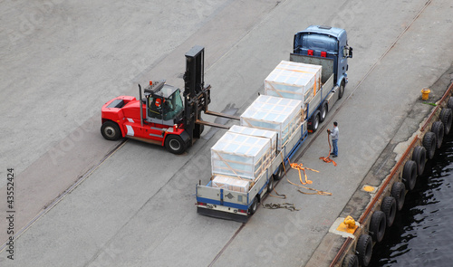Foto: Small auto-loader unload truck, labourer help, view from above Small auto-loader unload truck, labourer help, view from above