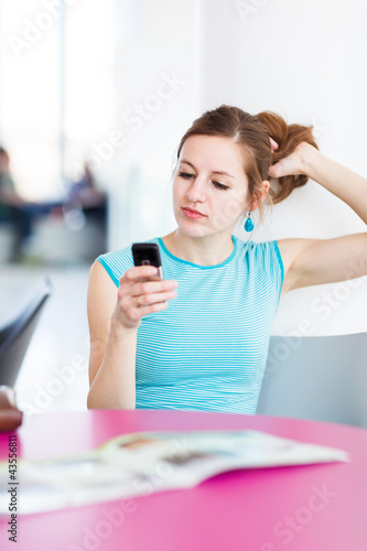 Foto: Pretty young woman using her mobile phone Pretty young woman using her mobile phone