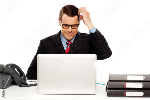 Photo: Confused male manager itching his head Confused male manager itching his head
