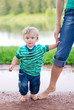 child with his mother walking on the puddles after the rain