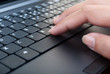 Hand pushing laptop keyboard.