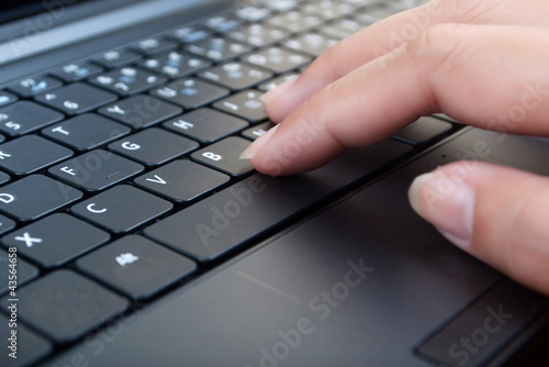 Photo: Hand pushing laptop keyboard. Hand pushing laptop keyboard.