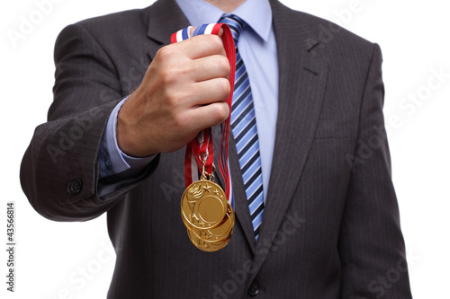 Photo: Businessman holding gold medal Businessman holding gold medal