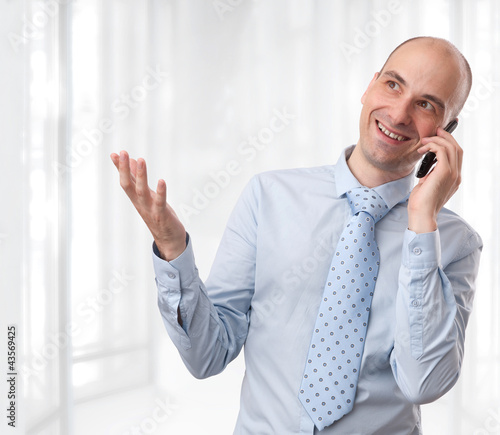 Foto: businessman smiling and talking on phone at office businessman smiling and talking on phone at office