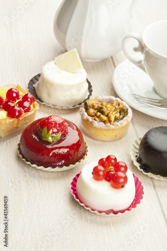 Foto: Different sort of beautiful pastry, small colorful sweet cakes Different sort of beautiful pastry, small colorful sweet cakes