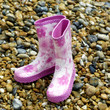 Pink children boots on the beach