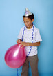 Boy tying up a blown balloon