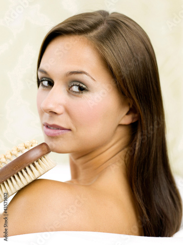 Photo: Woman holding a back scrub and massage brush Woman holding a back scrub and massage brush