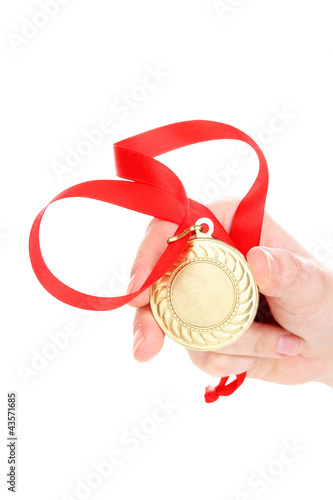 Photo: Gold medal in hand isolated on white Gold medal in hand isolated on white