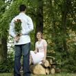 Man hiding a bouquet of flowers from his girlfriend