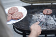 Man putting beef patties on the barbeque grill