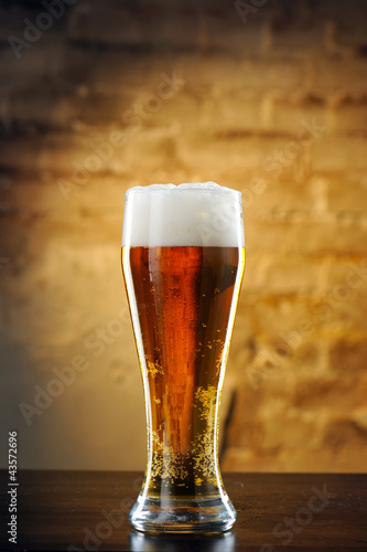 Photo: Glass of beer against a stone wall Glass of beer against a stone wall