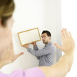 Man and woman hanging picture