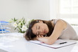 Woman lying down on desk in a home office