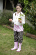 Girl holding a tomato and a tomato plant