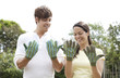 Man and woman looking at their dirty gardening gloves