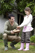 Girl putting potato into a basket held by the man