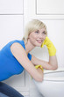 Woman with rubber gloves daydreaming in the bathroom