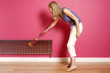 Woman dusting the radiator