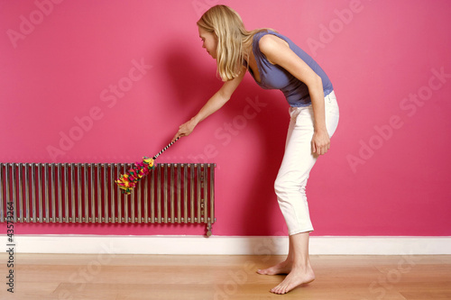 Photo: Woman dusting the radiator Woman dusting the radiator