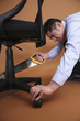 Businessman cutting chair with saw