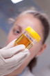 Woman examine urine container