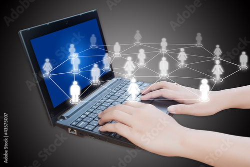 Photo: Hand pushing laptop keyboard with social network. Hand pushing laptop keyboard with social network.
