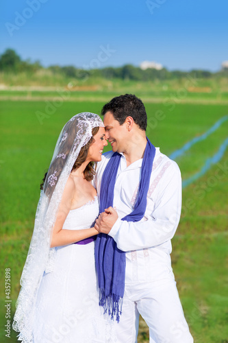 Foto: Couple in wedding day hug in green meadow Couple in wedding day hug in green meadow