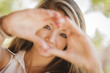 Photo: Attractive Smiling Mixed Race Girl Portrait with Heart Hand Sign Attractive Smiling Mixed Race Girl Portrait with Heart Hand Sign