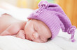 sleeping baby in an amusing violet hat
