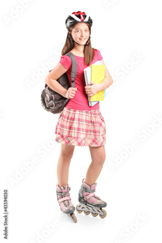 Photo: Full length portrait a girl on rollers holding notebooks Full length portrait a girl on rollers holding notebooks