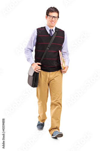 Photo: Student walking with notebooks in his hand Student walking with notebooks in his hand