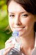 Young woman with bottle of water outdoors