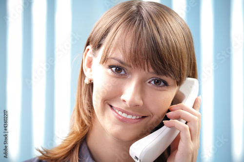 Photo: Young business woman with phone at office Young business woman with phone at office